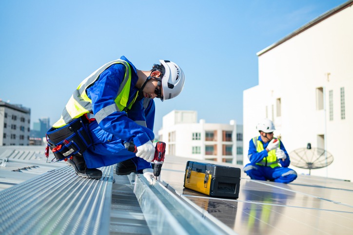 Workers applying roofing materials during a commercial roofing installation in Covington