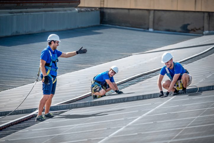 Workers installing a roof as part of a commercial roofing project in West Memphis